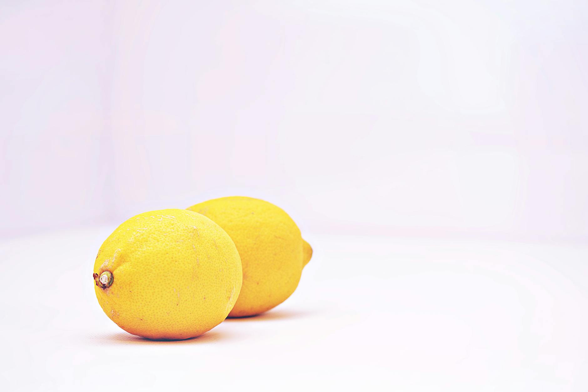 Fresh lemons on a clean white background representing different approaches to pleasure